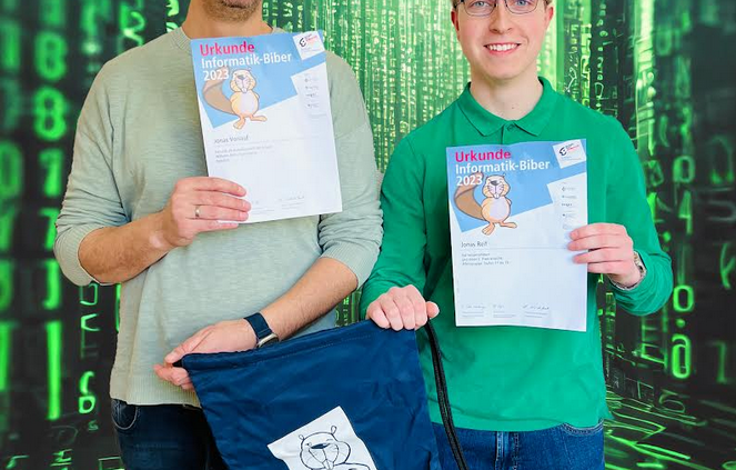 Herr Vorlauf und Jonas Reif präsentieren stolz ihren Wettbewerbspreis - Urkunde und Turnbeutel