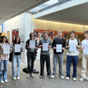 Gruppenbild des Mathe-LKs mit Urkunden vor der Uni in Landau
