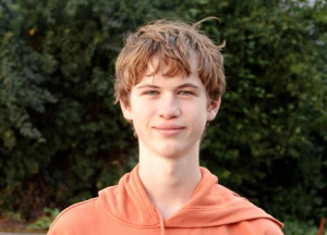 ein blonder, junger Mann schaut freundlich