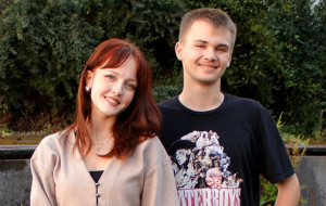 eine Schülerin und ein Schüler gucken freundlich