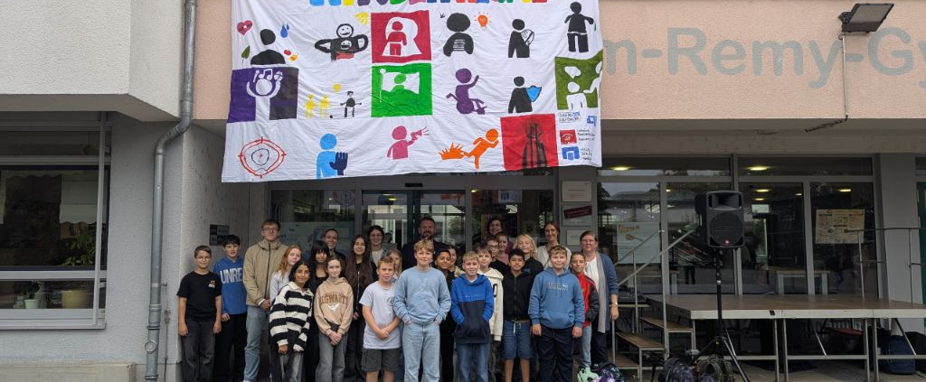 Die Beteiligten der Aktion sind auf einem Gruppenfoto unterhalb des aufgespanntes Banners zu sehen.