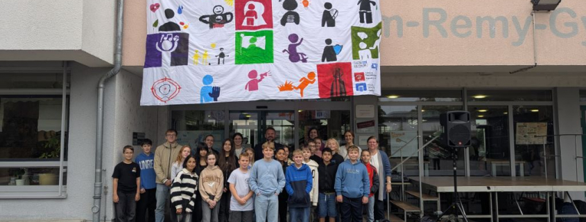 Die Beteiligten der Aktion sind auf einem Gruppenfoto unterhalb des aufgespanntes Banners zu sehen.
