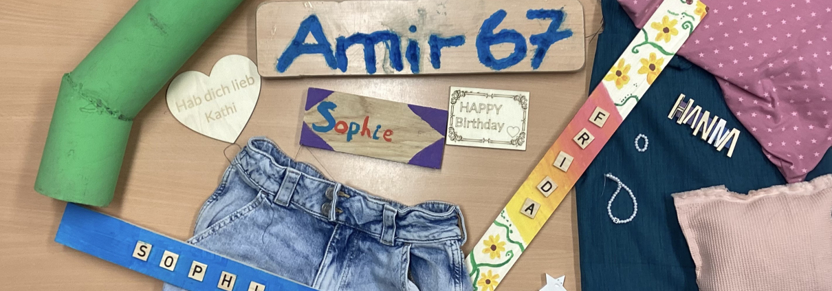 verschiedene DIY-Produkte liegen auf einem Tisch: Schilder, upgecycelte Jeans, Armbänder...