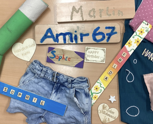 verschiedene DIY-Produkte liegen auf einem Tisch: Schilder, upgecycelte Jeans, Armbänder...