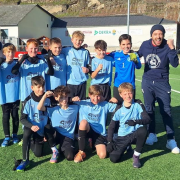 Gruppenbild auf Sportplatz: 10 Fußballer und 2 Betreuer