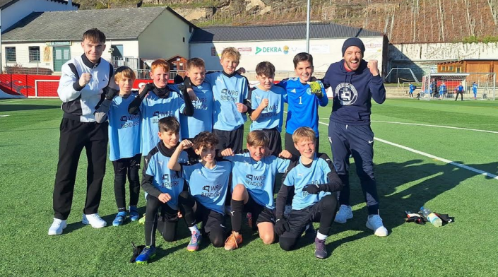 Gruppenbild auf Sportplatz: 10 Fußballer und 2 Betreuer