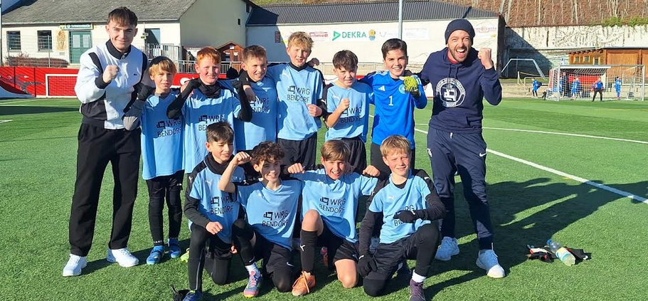 Gruppenbild auf Sportplatz: 10 Fußballer und 2 Betreuer