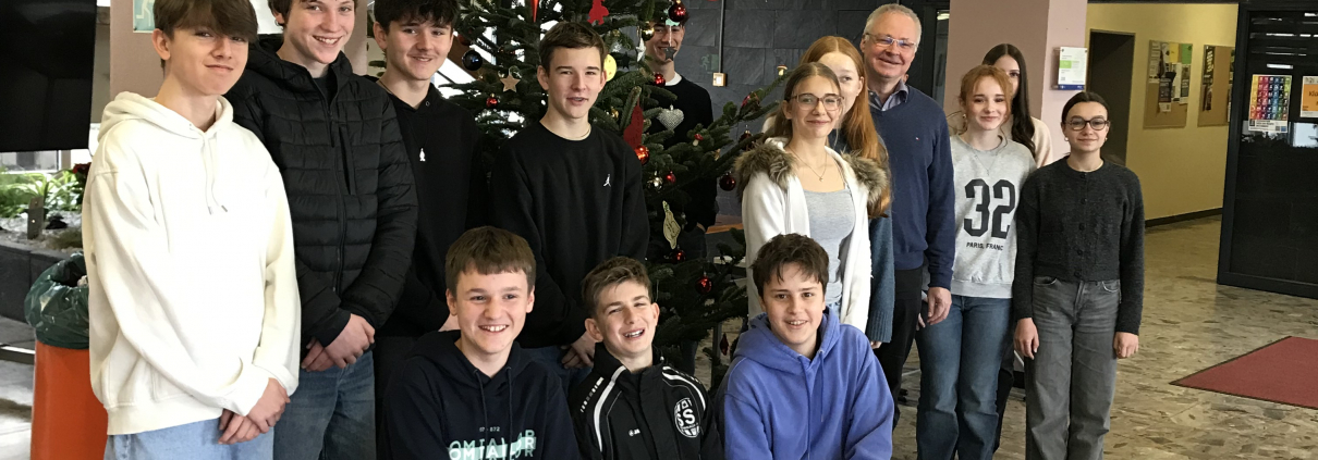 Die Religionsgruppe steht vor dem geschmückten Weihnachtsbaum