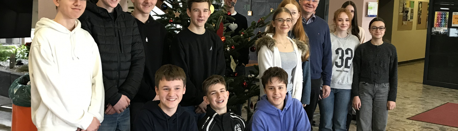 Die Religionsgruppe steht vor dem geschmückten Weihnachtsbaum