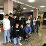 Die Religionsgruppe steht vor dem geschmückten Weihnachtsbaum