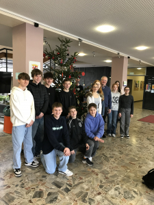 Die Religionsgruppe steht vor dem geschmückten Weihnachtsbaum