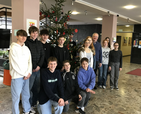 Die Religionsgruppe steht vor dem geschmückten Weihnachtsbaum