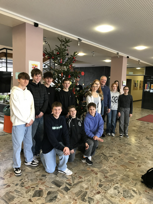Baum der frohen Botschaft – 9ab KR Christbaumschmücken WRG Bendorf 26-11-2025 Die Religionsgruppe steht vor dem geschmückten Weihnachtsbaum
