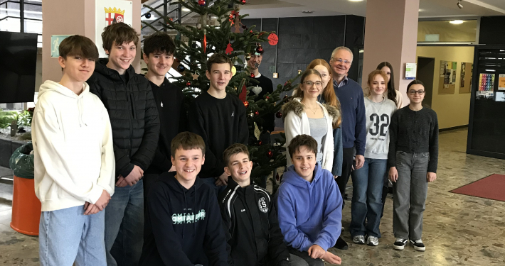 Die Religionsgruppe steht vor dem geschmückten Weihnachtsbaum
