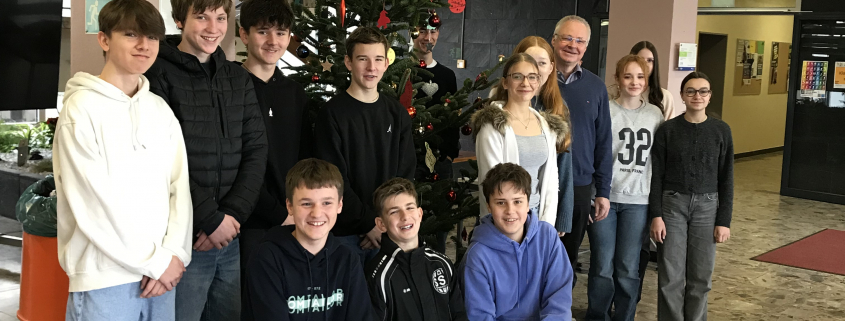 Die Religionsgruppe steht vor dem geschmückten Weihnachtsbaum