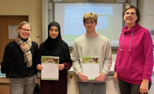 Gruppenbild: In der Mitte zwei Schüler mit einer Urkunde, eingerahmt von Fachlehrerin und Schulleiterin