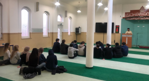 Innenansicht Moschee - Schülergruppe sitzt auf dem Teppichboden
