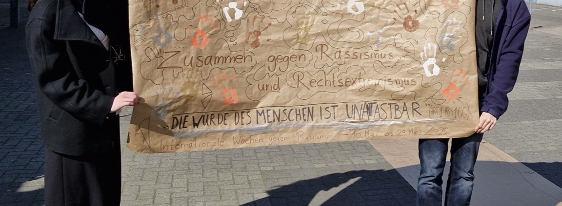 Das Schülersprecherteam mit dem beschrifteten Plakat.