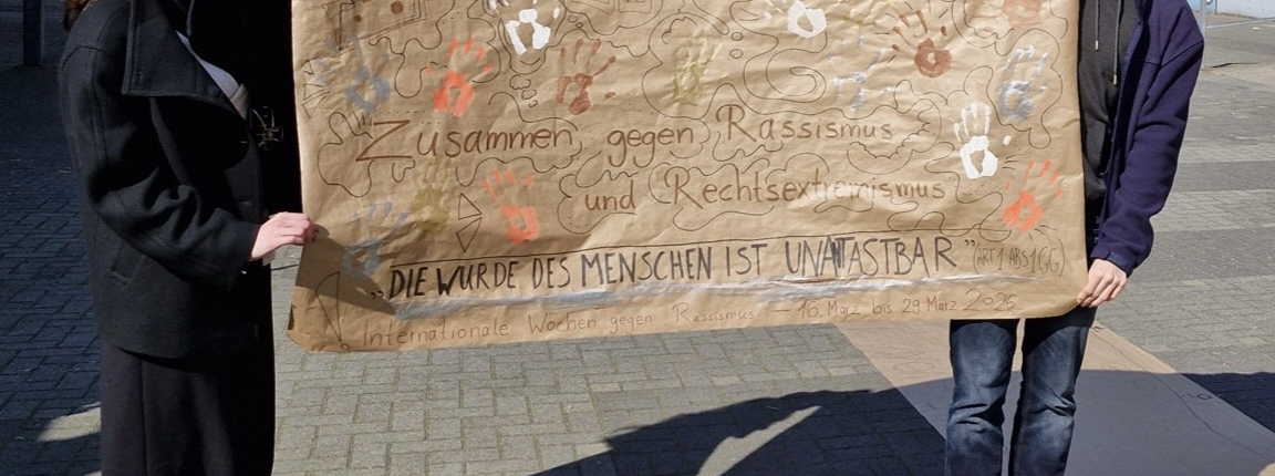 Das Schülersprecherteam mit dem beschrifteten Plakat.