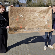 Das Schülersprecherteam mit dem beschrifteten Plakat.