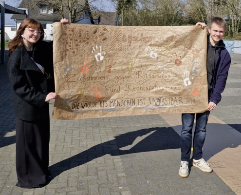Das Schülersprecherteam mit dem beschrifteten Plakat.