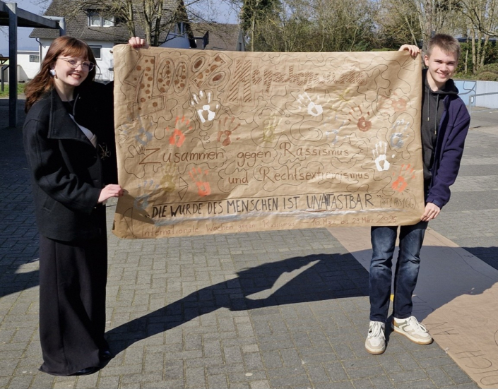 1000023751 Das Schülersprecherteam mit dem beschrifteten Plakat.