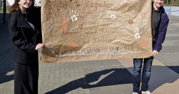 Das Schülersprecherteam mit dem beschrifteten Plakat.