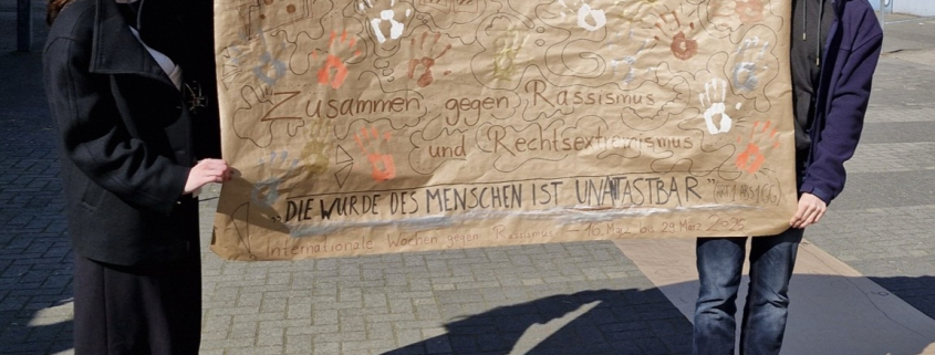 Das Schülersprecherteam mit dem beschrifteten Plakat.