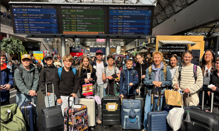 Frankreichaustausch 2026 eine Gruppe von 15 Schülerinnen und Schülern mit Gepäck wartet in einem französischem Bahnhof