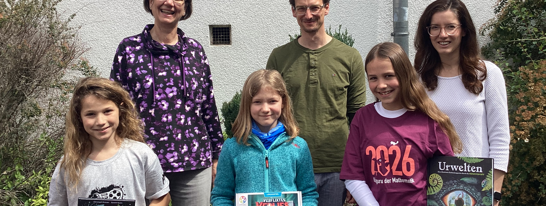 3 Schülerinnen, die Schulleiter und zwei Mathe-Kolleginnen freuen sich über die Buchpreise des Wettbewerbs.