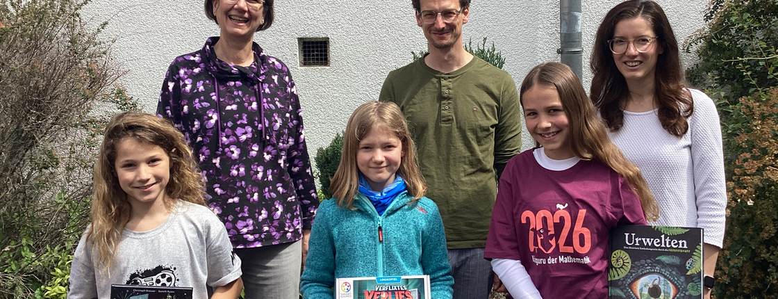 3 Schülerinnen, die Schulleiter und zwei Mathe-Kolleginnen freuen sich über die Buchpreise des Wettbewerbs.