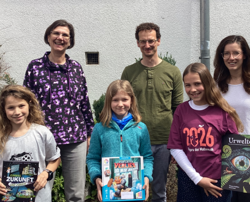 3 Schülerinnen, die Schulleiter und zwei Mathe-Kolleginnen freuen sich über die Buchpreise des Wettbewerbs.
