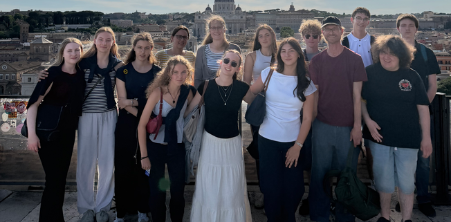 eine Schülergruppe steht vor der Stadt Rom