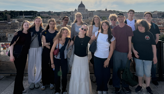 eine Schülergruppe steht vor der Stadt Rom