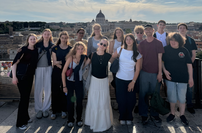 eine Schülergruppe steht vor der Stadt Rom